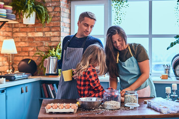 Family together cooking breakfast in loft style kitchen.
