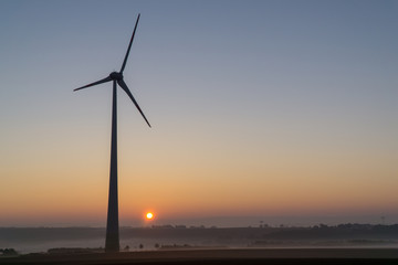 Wind turbines in the morning, partially covered by mist