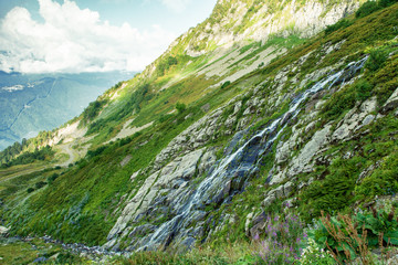 Caucasus Mountain waterfall at mountain valley background. Waterfall mountain valley landscape