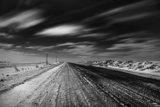 Empty freeway at night. Black and white. Road to the horizon. Clouds, rapidly running across the sky. © Владимир Никонов