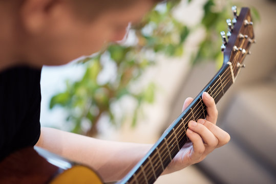 A man playing an acoustic guitar closeup. Learning music
