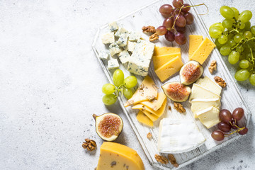 Cheese plate with grapes, figs and nuts.