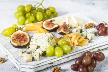 Cheese plate with grapes, figs and nuts.