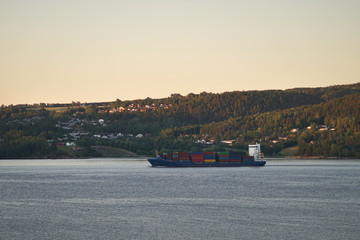 View of container ship in fjord.
