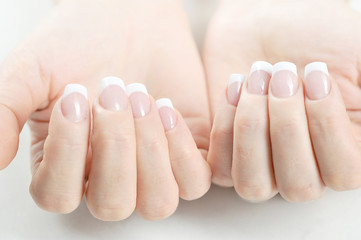 Two women hands with french manicure. Close-up. White background.