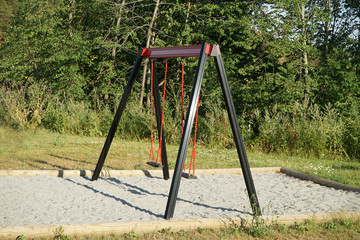 Fototapeta na wymiar Empty swings on playground.