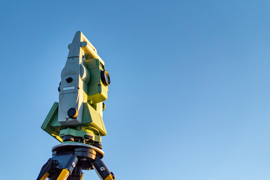 Surveyor equipment (theodolit or total positioning station) with blue sky in background during sunrise