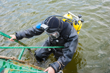 Diver in a diving suit and helmet ready to dive