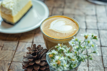 Fototapeta na wymiar The hot latte art coffee with cake
