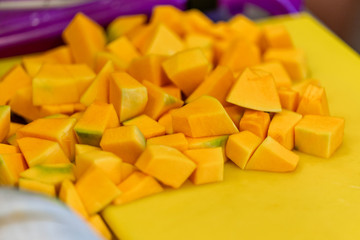 Cutted Pumpkin Pieces on the Yellow Plastic Board