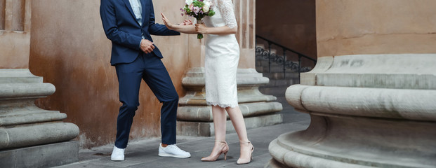 young wedding couple holding hands, groom and bride