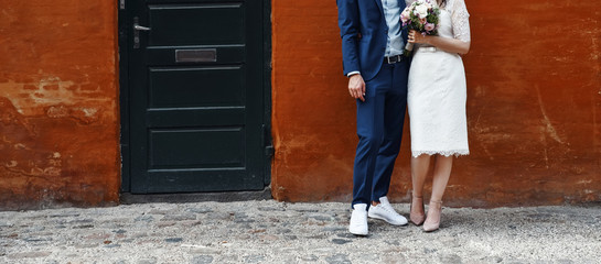 young wedding couple holding hands, groom and bride