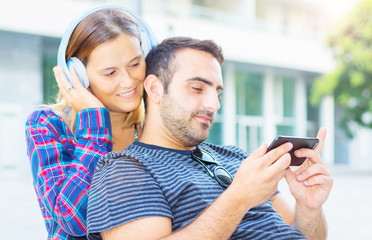 young couple listening and watching music on the phone
