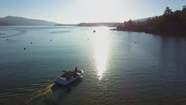 Aerial Follow Fishing Boat on the Lake at Sunrise