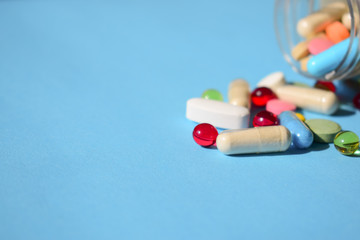 Medicines banned, pills recall. Multicolored bright various type pills and capsules spilling out of...