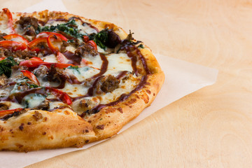 Pizza on a wooden table close-up. Freshly baked pizza on a wooden surface close-up.