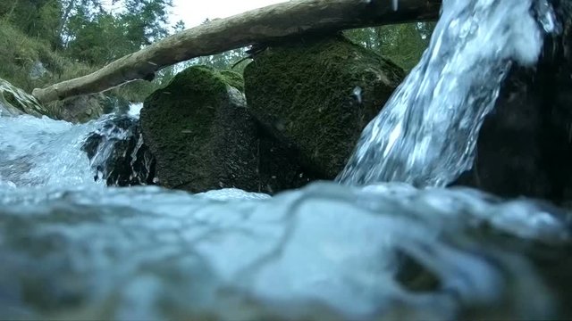 Wasserfall im Gebirge mit umgefallenem Baum