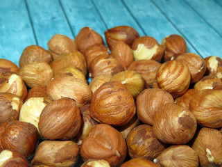 Hazelnuts on a wooden table close-up. Heap of raw filbert nuts, protein food