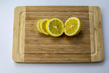a chopping board with sliced lemons, top front view, isolated background