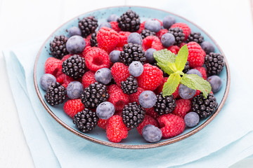 Fresh raspberries in a plate on a  vintage background.