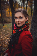 Portrait of the girl in the red coat in autumn park