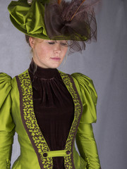 Victorian woman in green ensemble with hat