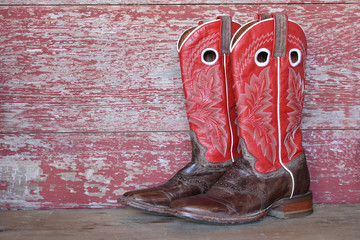 red cowboy boots on red barn board