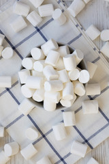 White fluffy marshmallows in a bowl, top view. Flat lay, from above, overhead. Close-up.