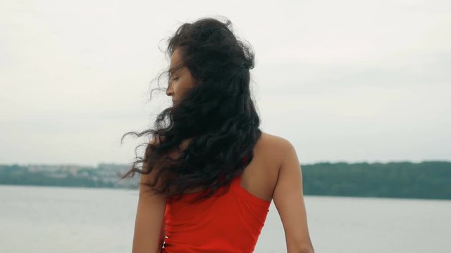 Beautiful woman dancer Kizomba and Bachata outdoors. mixed race woman in red dress