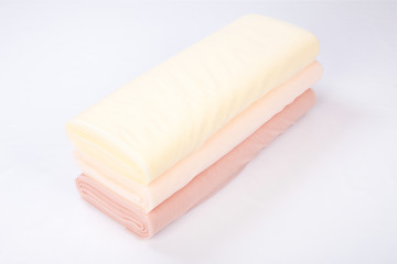 rolls of fabric lie on a white background. gradient beige