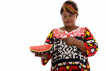 Studio shot of fat black African woman holding and pointing at s