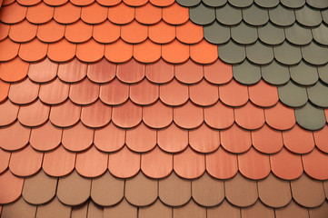 Roof tiles of the same shape but differing in color and surface finish. Roofing.