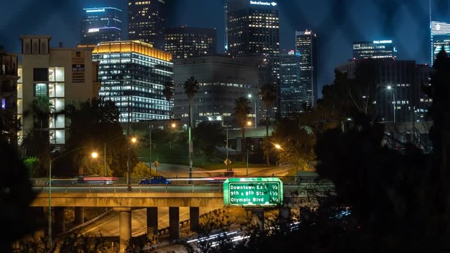 DTLA Moving Time-lapse. View from the Echo Park neighborhood in East Los Angeles looking through a fence overlooking downtown and the 101 freeway.