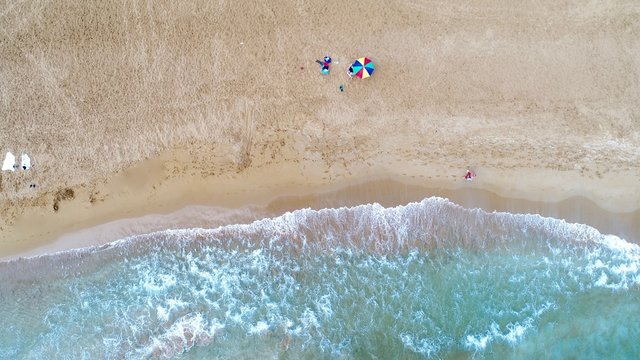 Aerial view of alone colorful umbrella on the beach. Holiday concept top view.