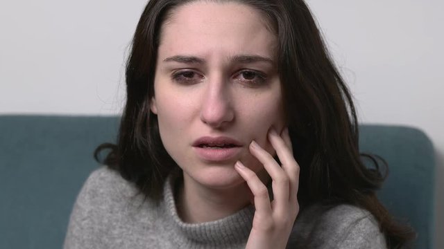 close up on suffering, pain, despair.Young depressed woman cries