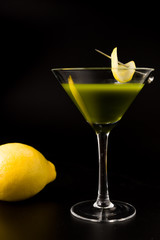 green tea cocktail with lemon on black background