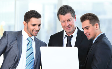 Fototapeta premium business partners with a laptop standing in the lobby of the office.