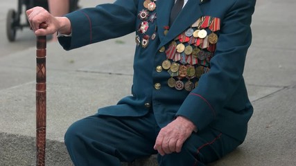 World war veteran with cane stick. Old senior ussr warrior with many awards medals. World war victory celebration, may of 9.