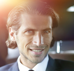 Businessman inside a car working on his laptop