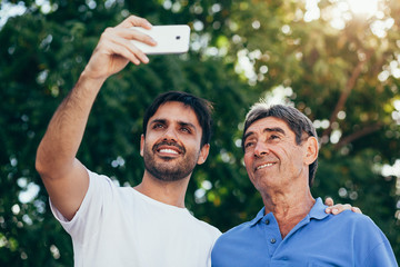Selfie portrait of father and adult son outdoor