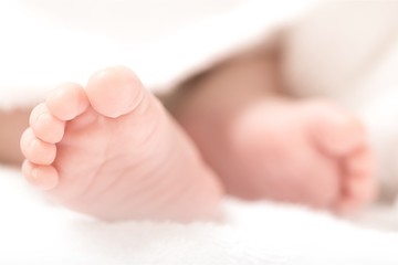 New born baby hand on light background
