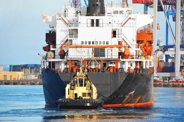 Tugboat assisting bulk cargo ship