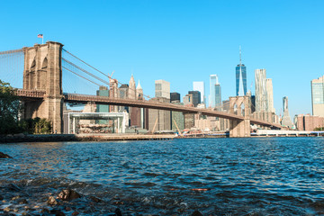 Fototapeta premium Widok na Brooklyn Bridge i Manhattan skyline w świetle wczesnego poranka słońca - centrum Nowego Jorku