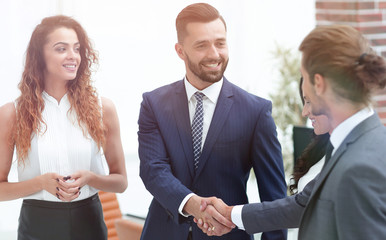 handshake business partners in the office.