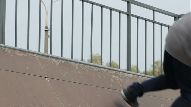 Skater make trick 50-50 grind on edge of ramp radius, close-up, slowmotion