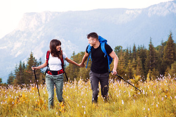 Young hikers couple with backpack on mountain 