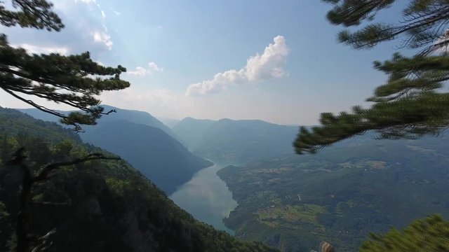 Flying from viewpoint Banjska stena rock at Tara mountain looking down to Canyon of Drina river, Serbia, 4k