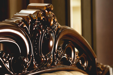 Close-up Brown wooden carved patterns headboard of a double bed. Retro Stylish Bedroom