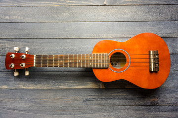 Small Ukulele guitar on wooden backdrop