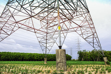 Electricity pylon base on agriculture area, Transmission line of electricity to rural field, Electricity tower with nature landscape